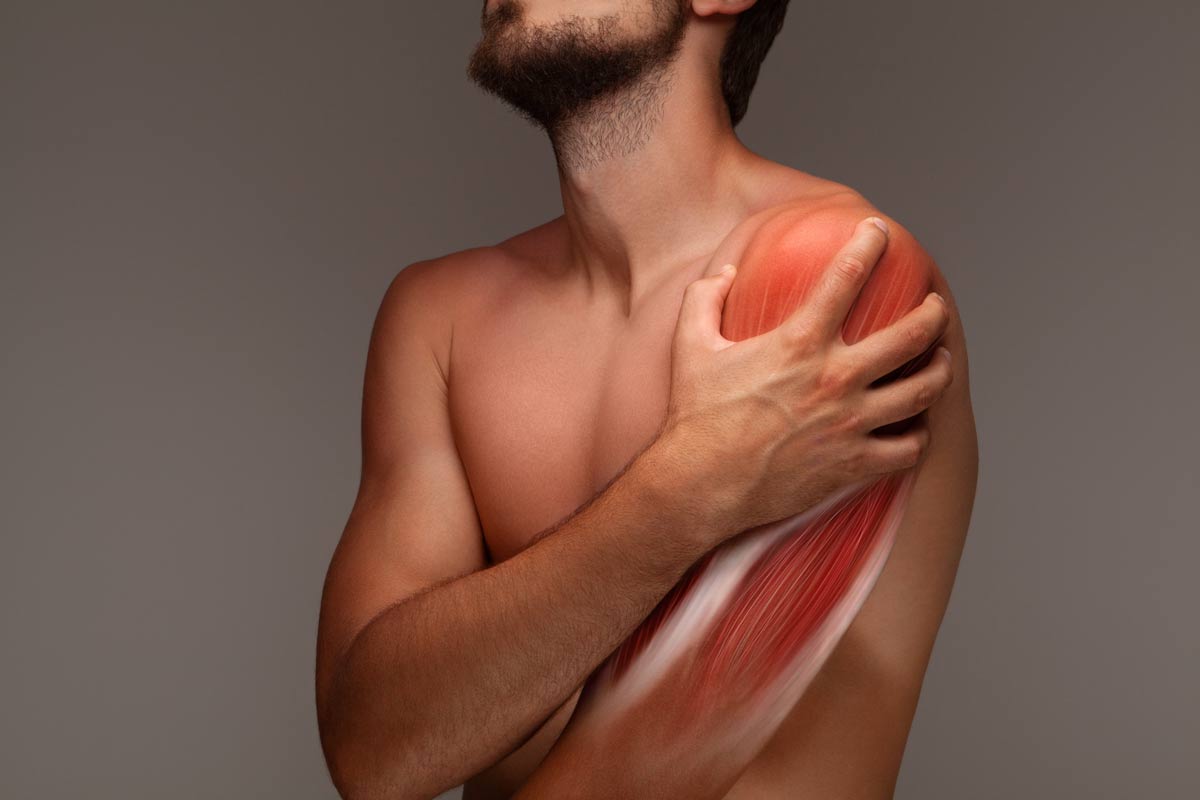 homem segurando um dos braços com dor por capsulite adesiva